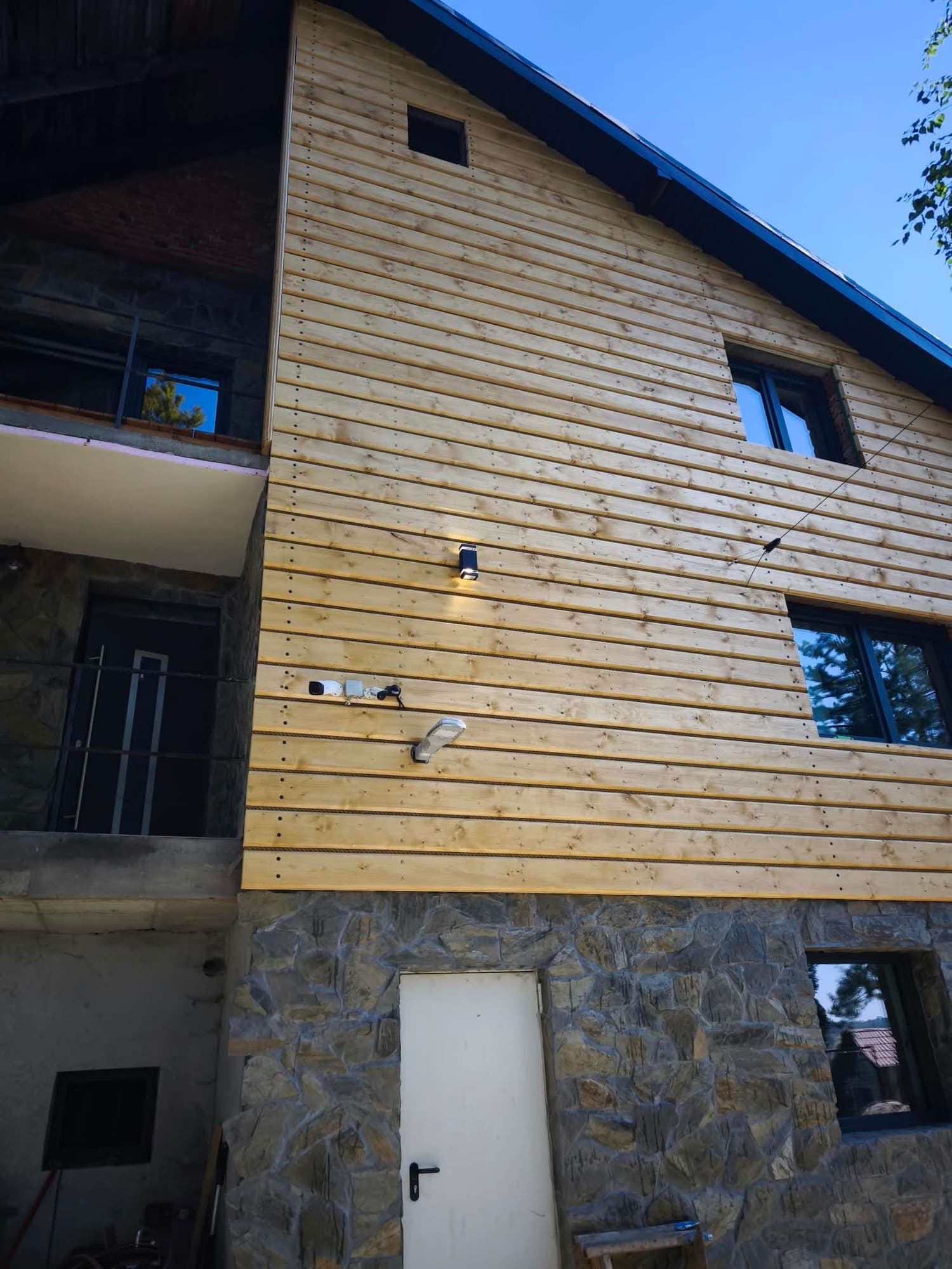 Elewacja budynku z bali drewnianych na kamiennym cokole